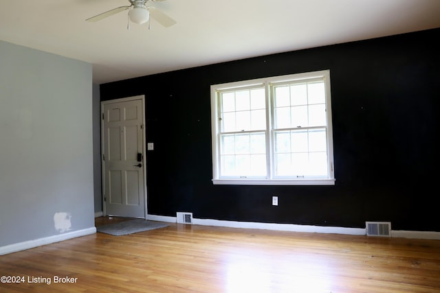 empty room with ceiling fan and light wood-type flooring