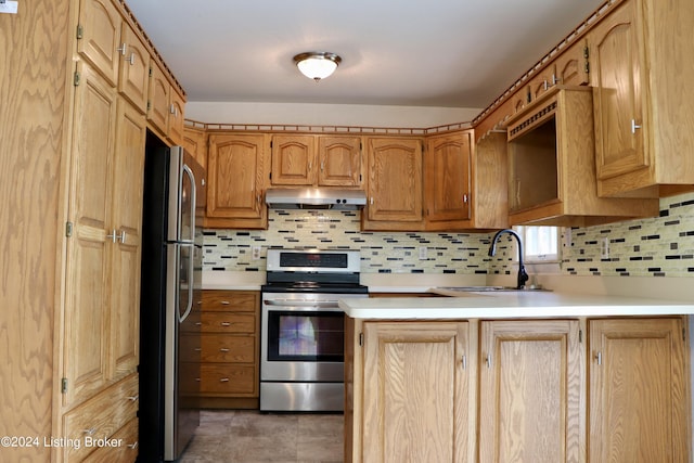 kitchen with appliances with stainless steel finishes, sink, and decorative backsplash