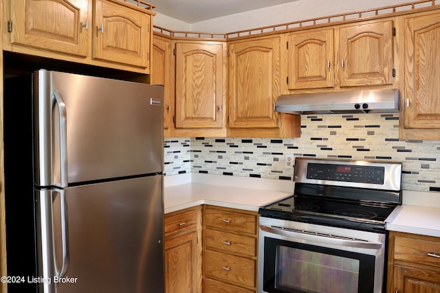 kitchen featuring appliances with stainless steel finishes, ventilation hood, and backsplash