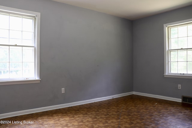 unfurnished room featuring dark parquet flooring