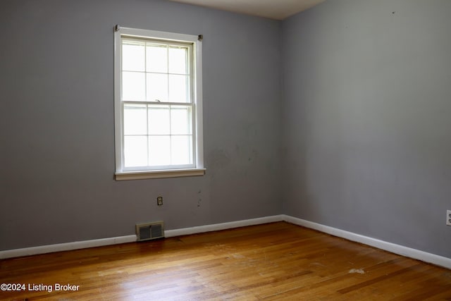 unfurnished room with a healthy amount of sunlight and light hardwood / wood-style floors