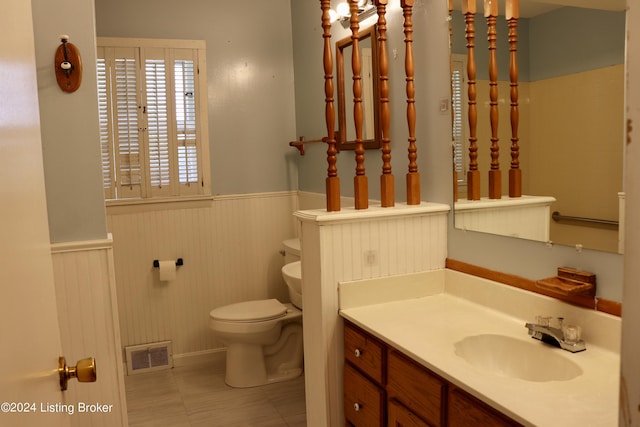 bathroom featuring vanity, tile patterned floors, and toilet