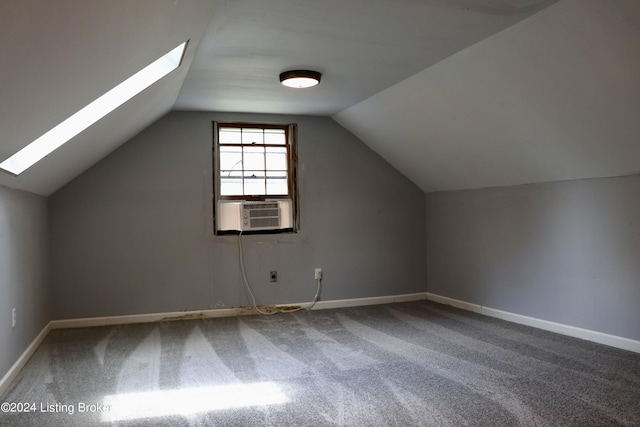 additional living space featuring cooling unit, vaulted ceiling with skylight, and carpet