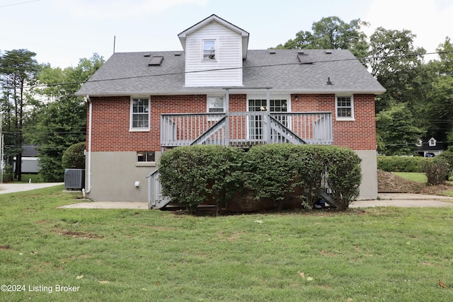 rear view of property featuring a wooden deck, a yard, and cooling unit