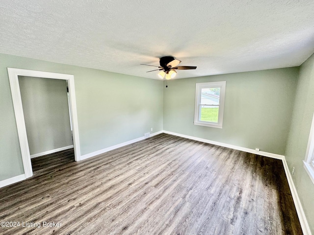 empty room featuring ceiling fan, hardwood / wood-style floors, and a textured ceiling