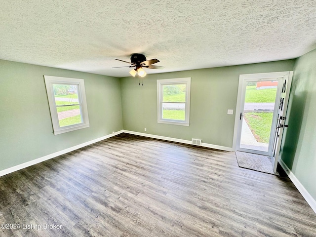 unfurnished room featuring ceiling fan, a wealth of natural light, and hardwood / wood-style floors