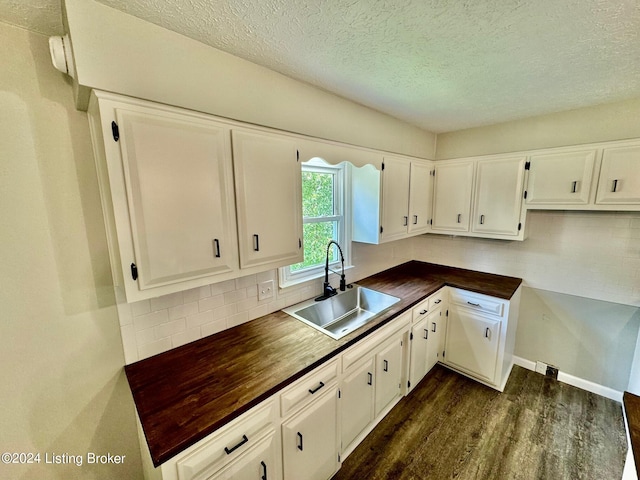 kitchen featuring backsplash, white cabinets, sink, and dark hardwood / wood-style flooring