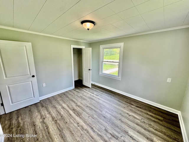 unfurnished bedroom featuring light wood-type flooring, crown molding, and a closet