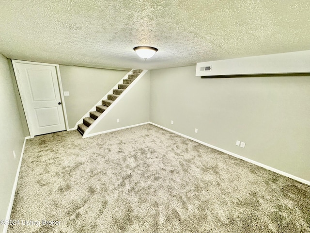 basement featuring carpet and a textured ceiling