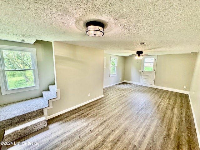 interior space featuring a textured ceiling, hardwood / wood-style floors, a wealth of natural light, and ceiling fan