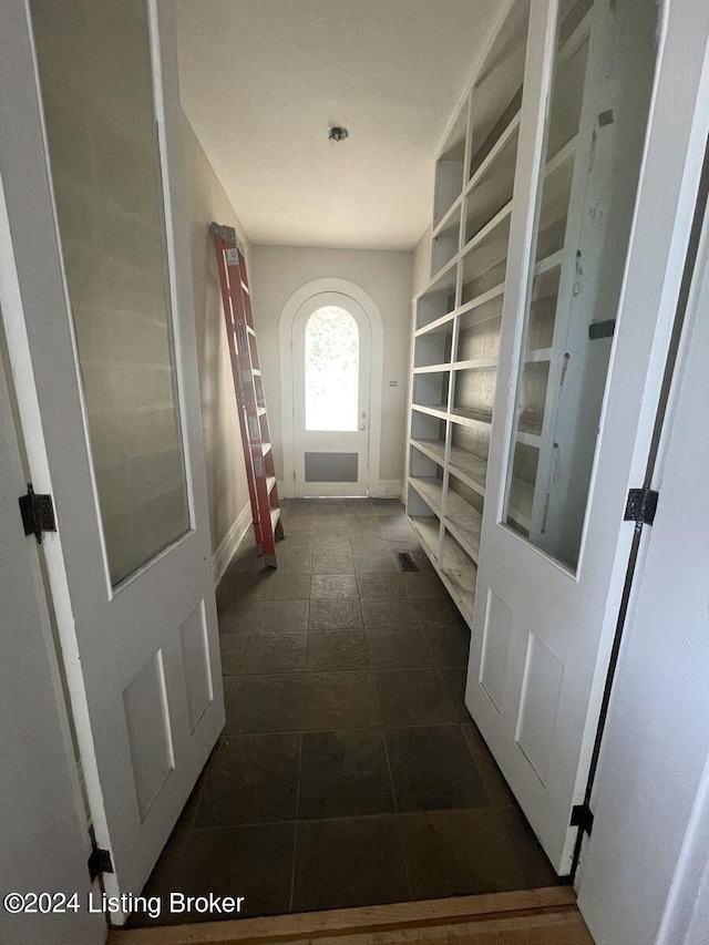 corridor featuring dark tile patterned floors