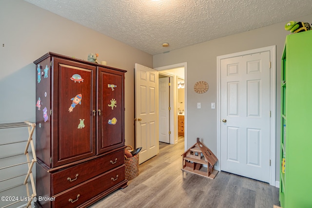 bedroom featuring a textured ceiling and light wood-type flooring