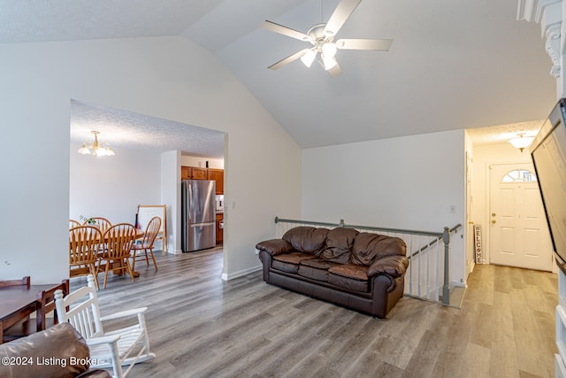 living room featuring light hardwood / wood-style flooring, ceiling fan with notable chandelier, and lofted ceiling