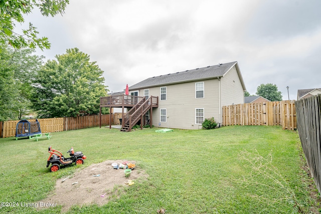 view of yard featuring a trampoline and a wooden deck