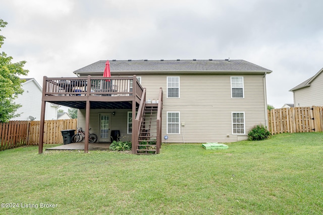 back of property featuring a lawn, a patio, and a wooden deck