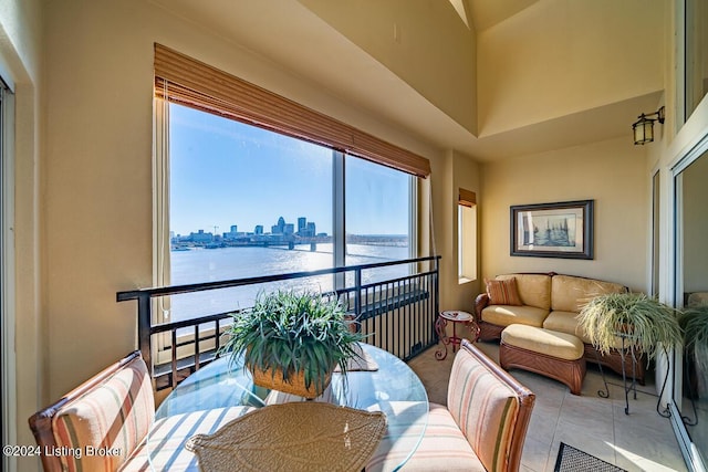 sunroom / solarium featuring a view of city and a water view