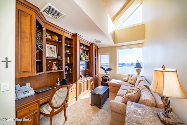 home office with light carpet, built in study area, and visible vents