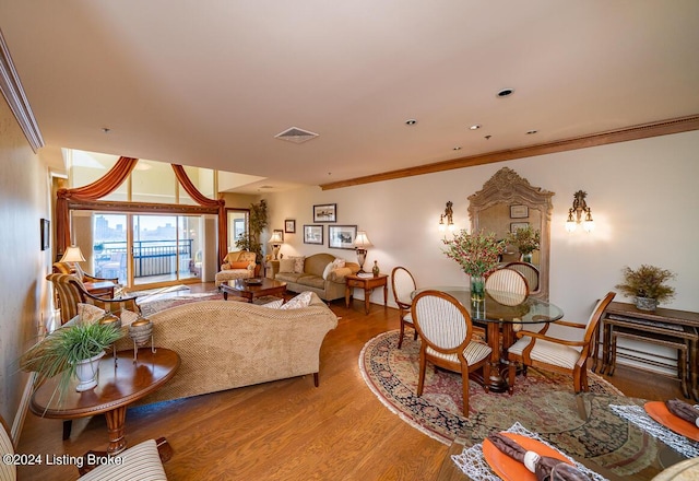 living area featuring crown molding, visible vents, and wood finished floors