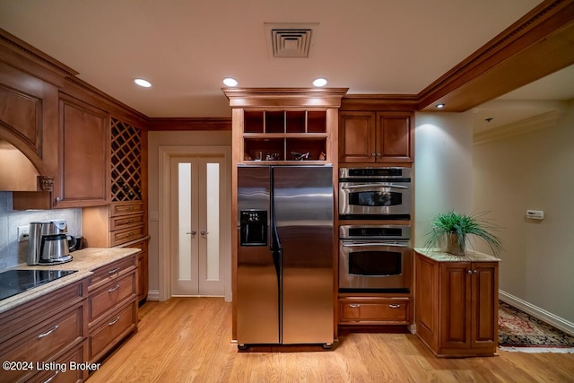 kitchen featuring stainless steel appliances, visible vents, light wood-style floors, backsplash, and crown molding