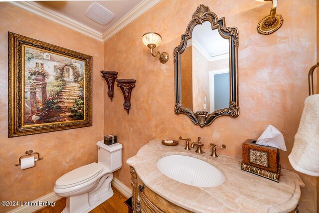 bathroom with ornamental molding, vanity, toilet, and baseboards