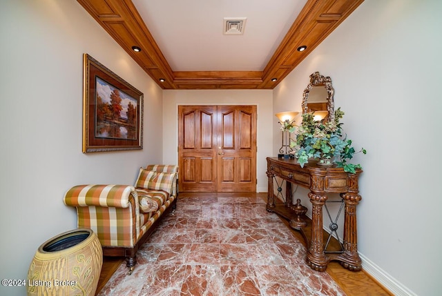 interior space featuring ornamental molding, a tray ceiling, visible vents, and baseboards