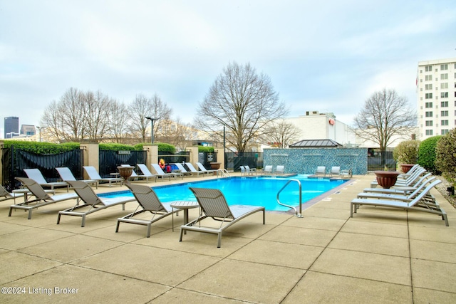 community pool featuring a fenced backyard and a patio