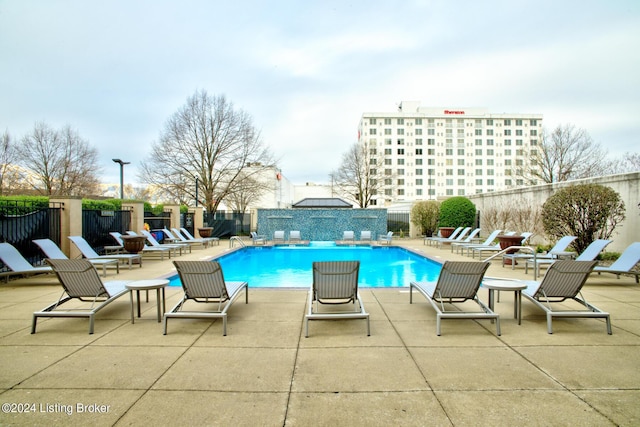 community pool with a patio area and a fenced backyard