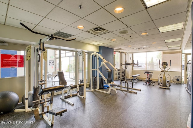 exercise room featuring a healthy amount of sunlight, visible vents, and a drop ceiling