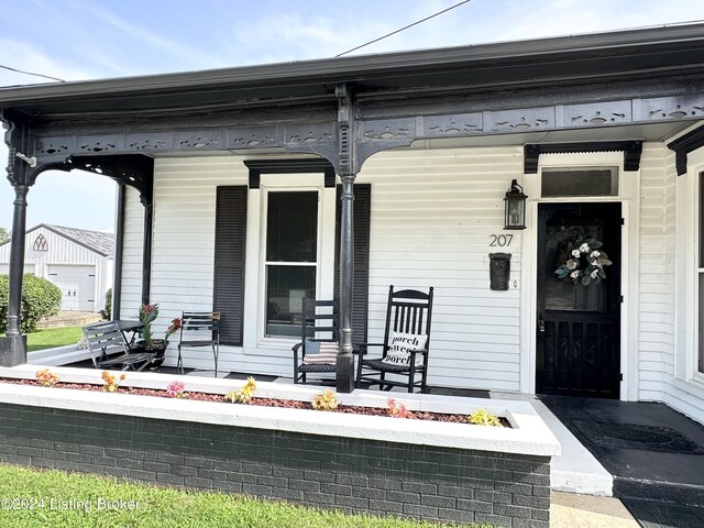 property entrance featuring a porch and a garage