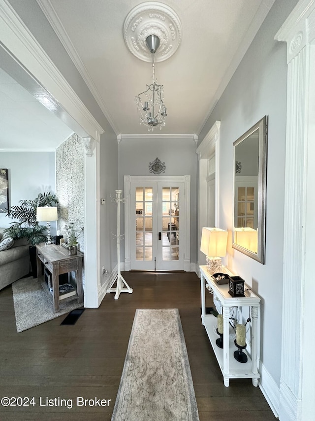 entryway with french doors, dark hardwood / wood-style floors, crown molding, and a notable chandelier