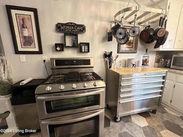 kitchen with white cabinetry, decorative backsplash, and appliances with stainless steel finishes