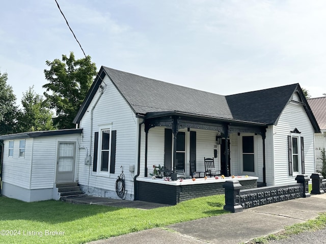 view of front of home with a front yard and covered porch