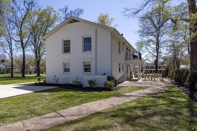 view of property exterior featuring a yard and a balcony