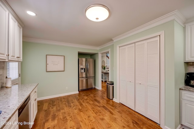 kitchen with backsplash, white cabinets, light wood-type flooring, and stainless steel appliances