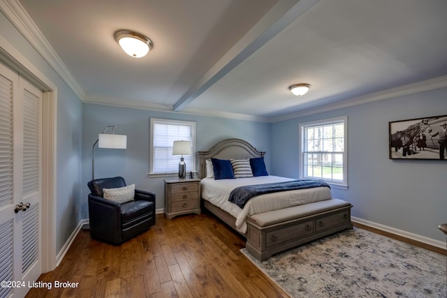 bedroom featuring a closet, wood-type flooring, and ornamental molding