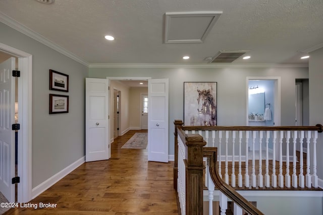 hallway featuring crown molding, a textured ceiling, and hardwood / wood-style floors