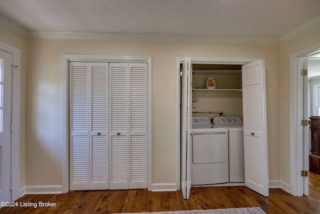 clothes washing area with washer and clothes dryer, crown molding, and hardwood / wood-style flooring