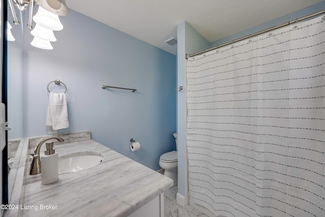 bathroom with an inviting chandelier, vanity, tile patterned flooring, and toilet