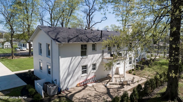 view of side of home featuring a patio, central AC, and a lawn