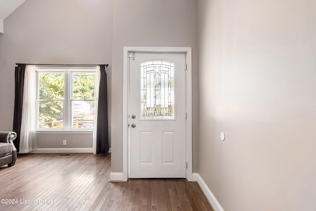 doorway with wood finished floors and baseboards