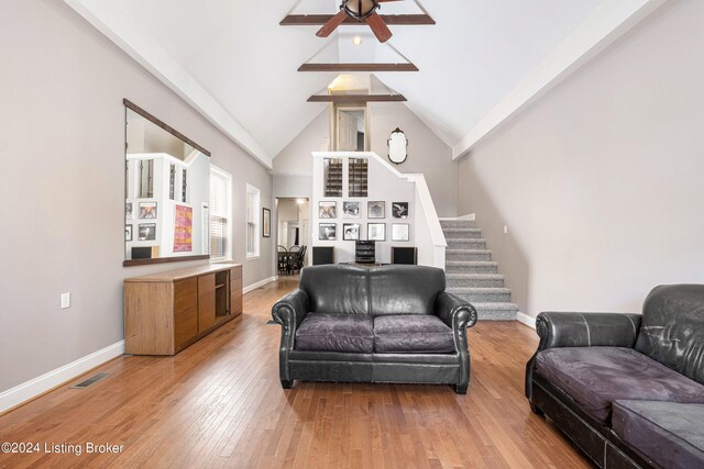 living room with high vaulted ceiling, ceiling fan, and light hardwood / wood-style flooring