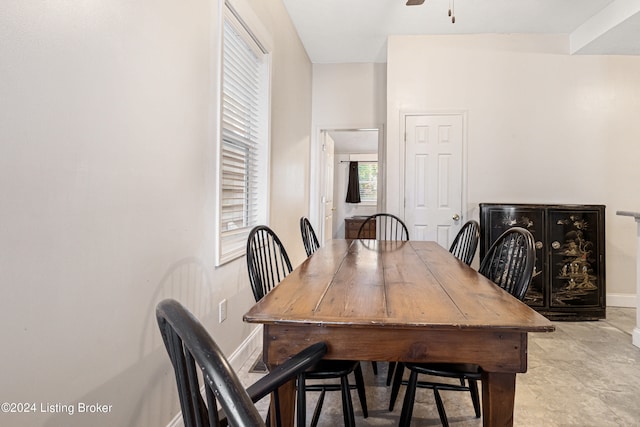 dining space featuring a ceiling fan and baseboards