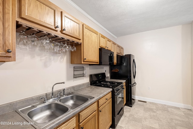 kitchen featuring crown molding, a sink, a textured ceiling, black appliances, and baseboards