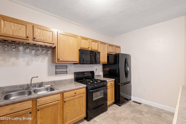 kitchen with light countertops, a sink, a textured ceiling, black appliances, and baseboards