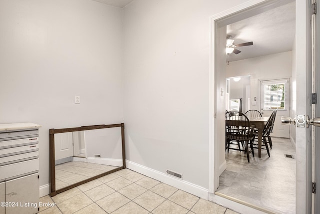 spare room featuring light tile patterned floors, ceiling fan, visible vents, and baseboards