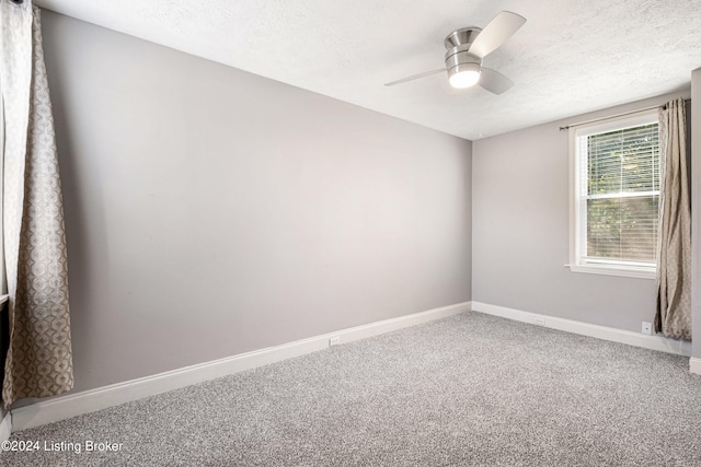 carpeted empty room featuring ceiling fan, a textured ceiling, and baseboards