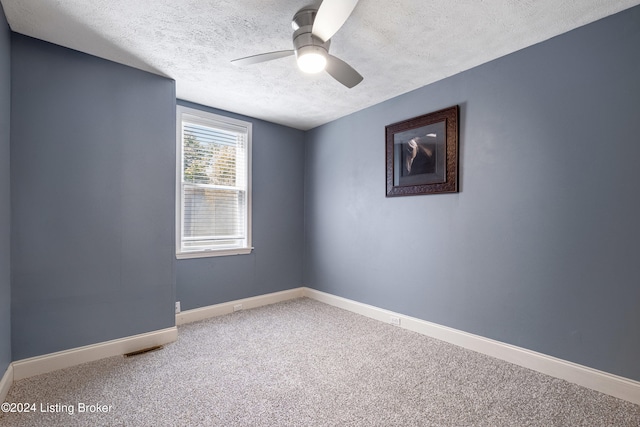 carpeted spare room featuring visible vents, ceiling fan, a textured ceiling, and baseboards