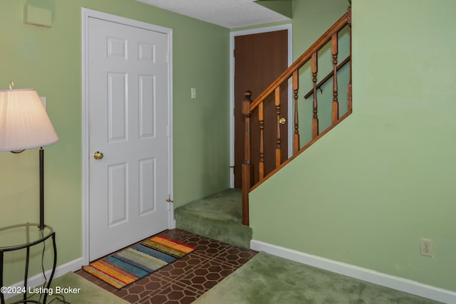 foyer with dark colored carpet