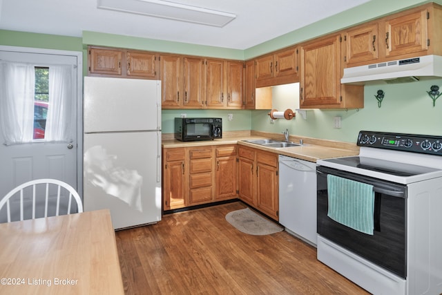 kitchen with hardwood / wood-style flooring, sink, and white appliances