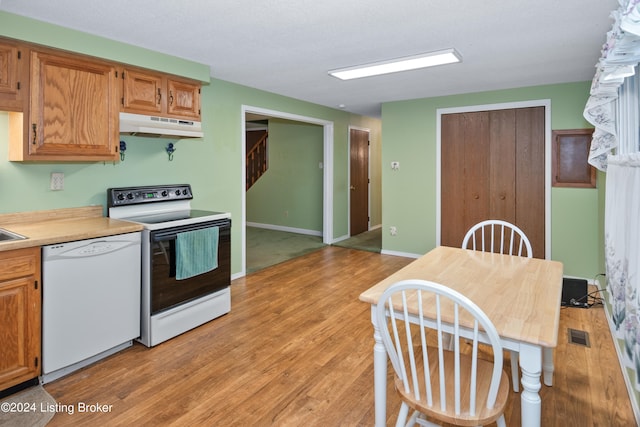 kitchen with white appliances and light hardwood / wood-style flooring